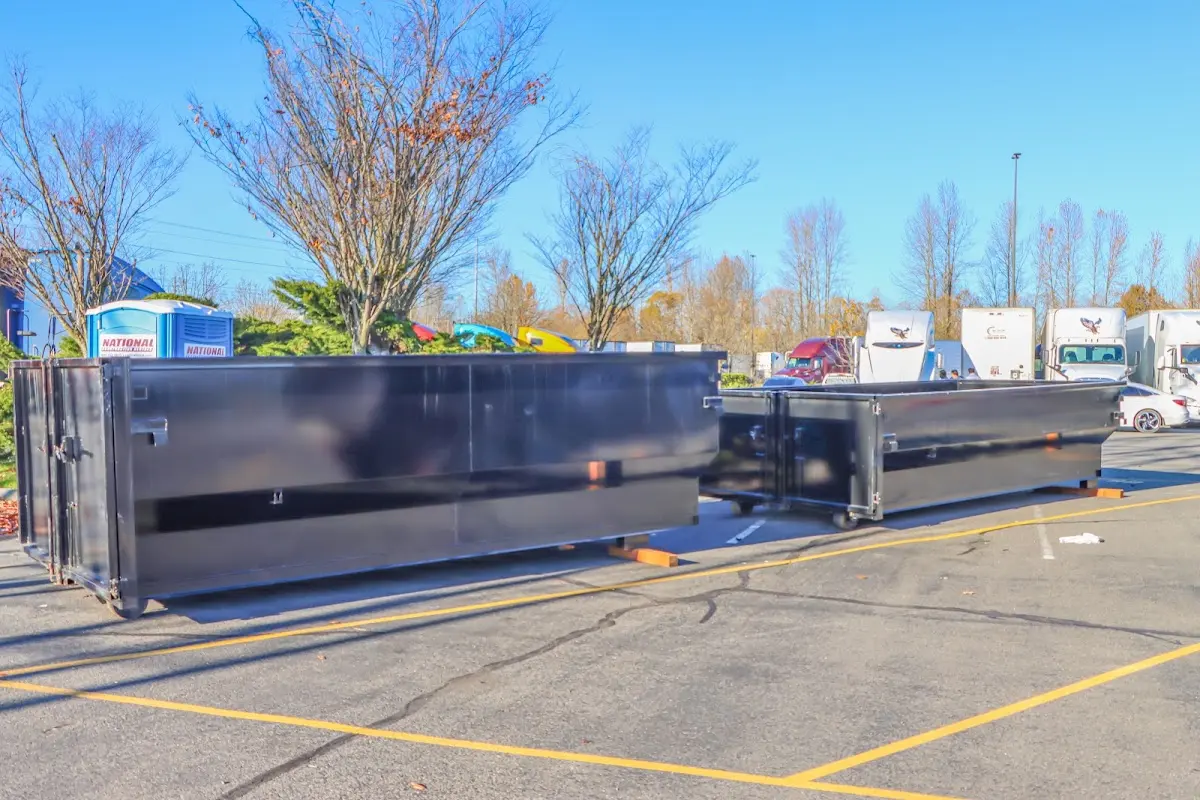 Professional dumpster rental service with roll-off container on residential driveway in Merrimack